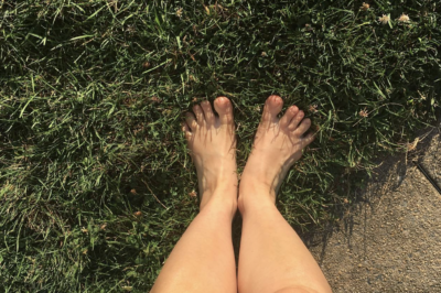 Photo of bare feet standing on grass