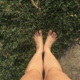 Photo of bare feet standing on grass